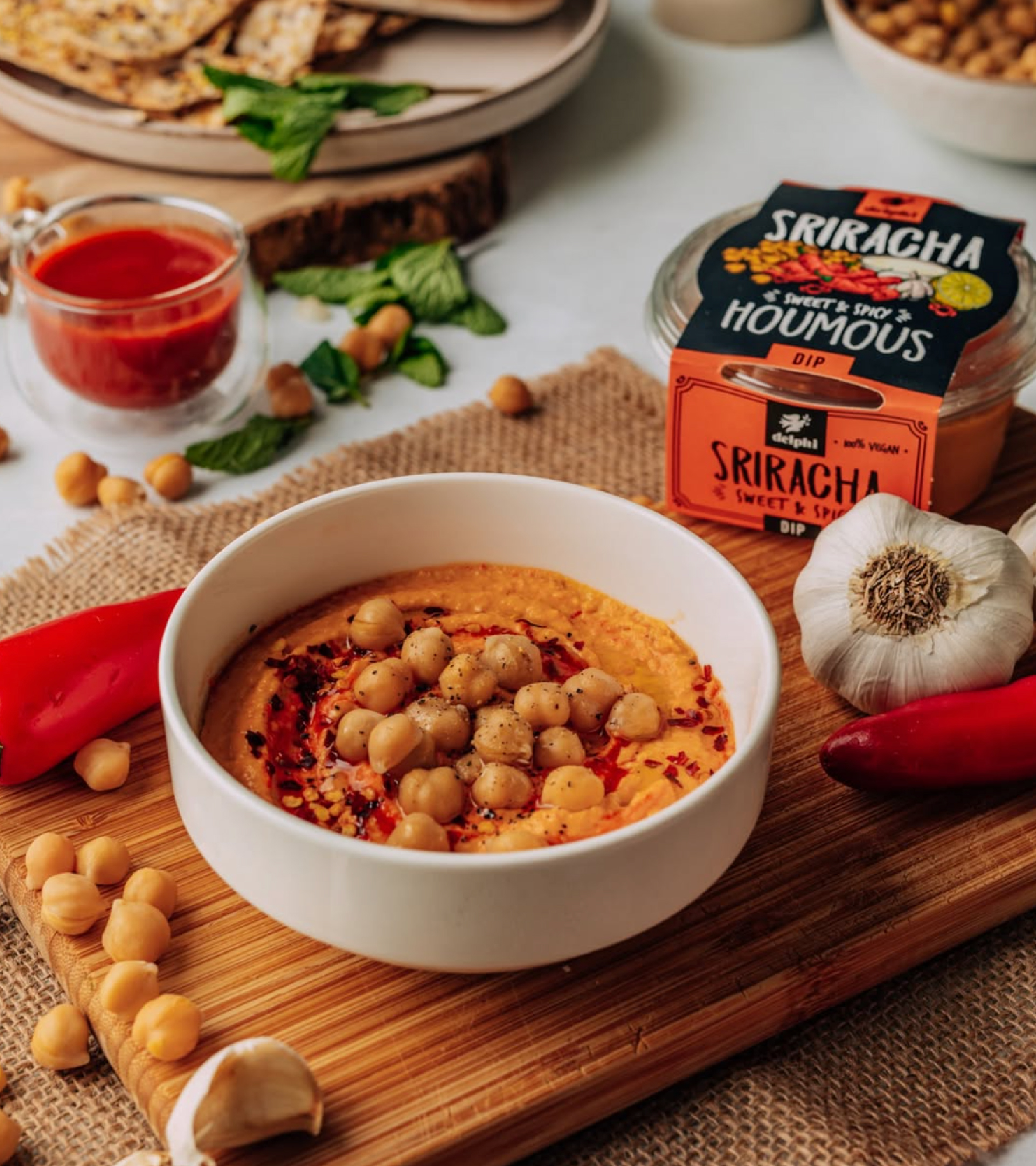 Sriracha Houmous in a bowl next to some delphi packging